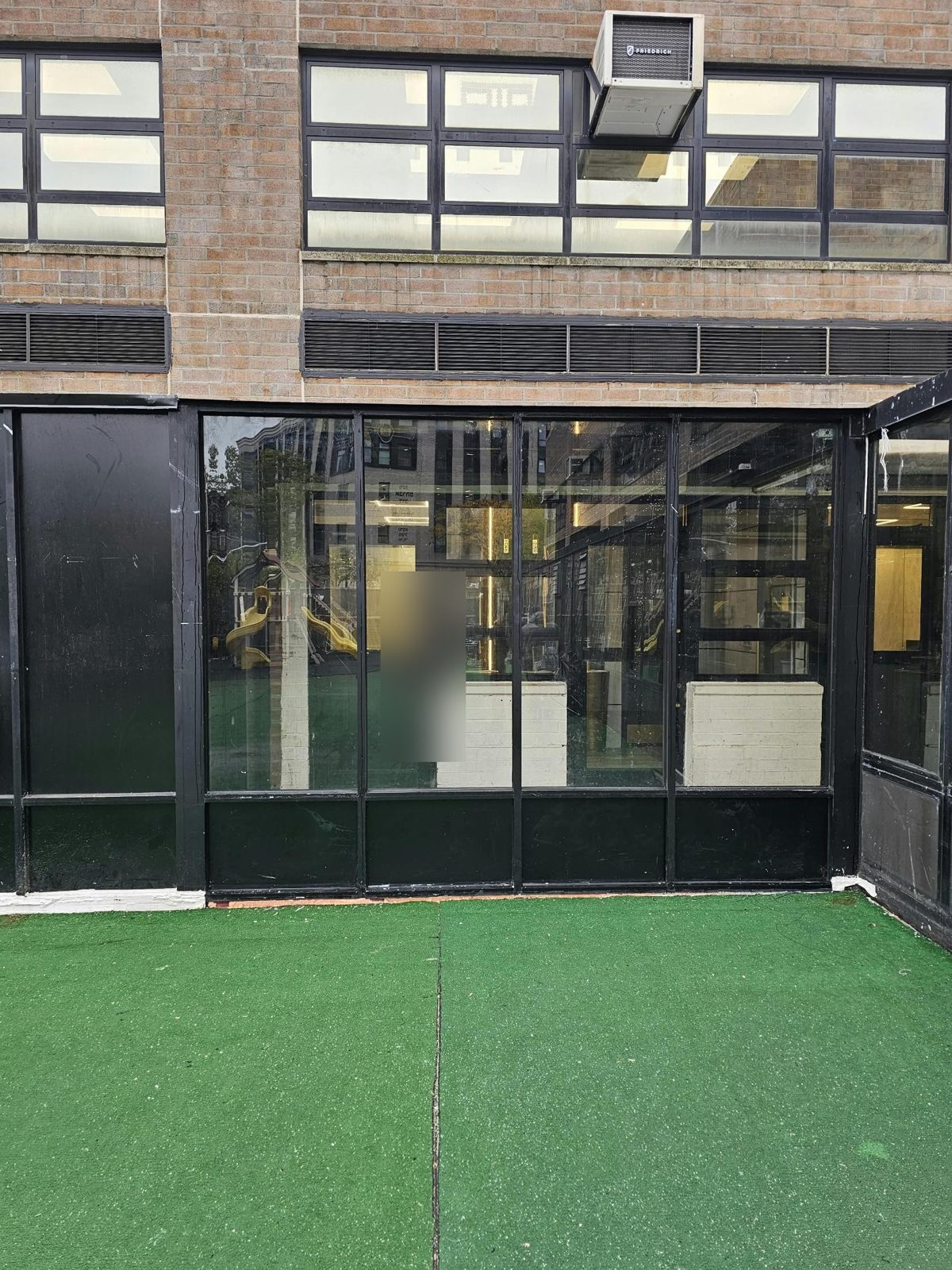 Glazed bays of the custom aluminum enclosure at 590 Bedford Avenue, Brooklyn, with divided lights under the building's louvers