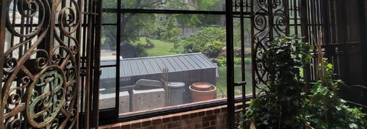 Laminated glass wall of the sunroom seen through the scrolled ironwork at 60 Herbert Avenue, Closter, NJ
