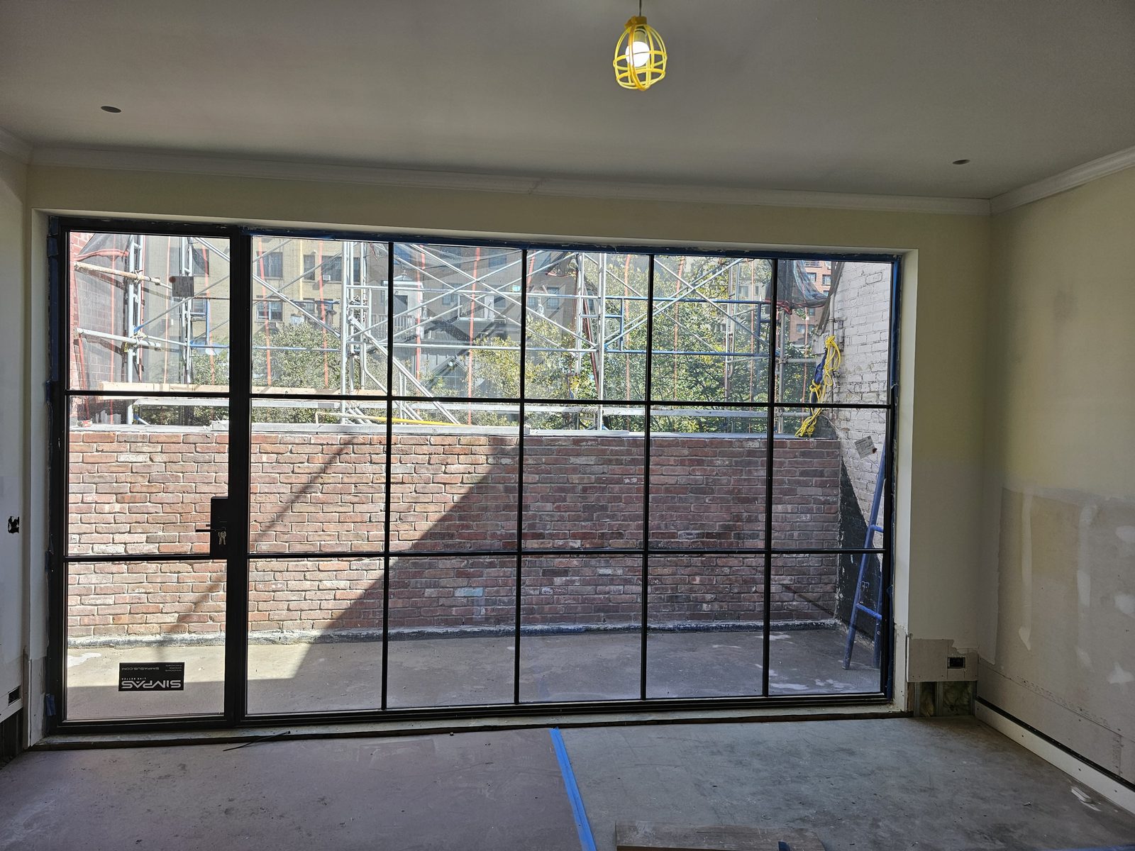 Black divided-lite SIMPAS sliding door on the top floor opening onto a terrace, East 70th Street