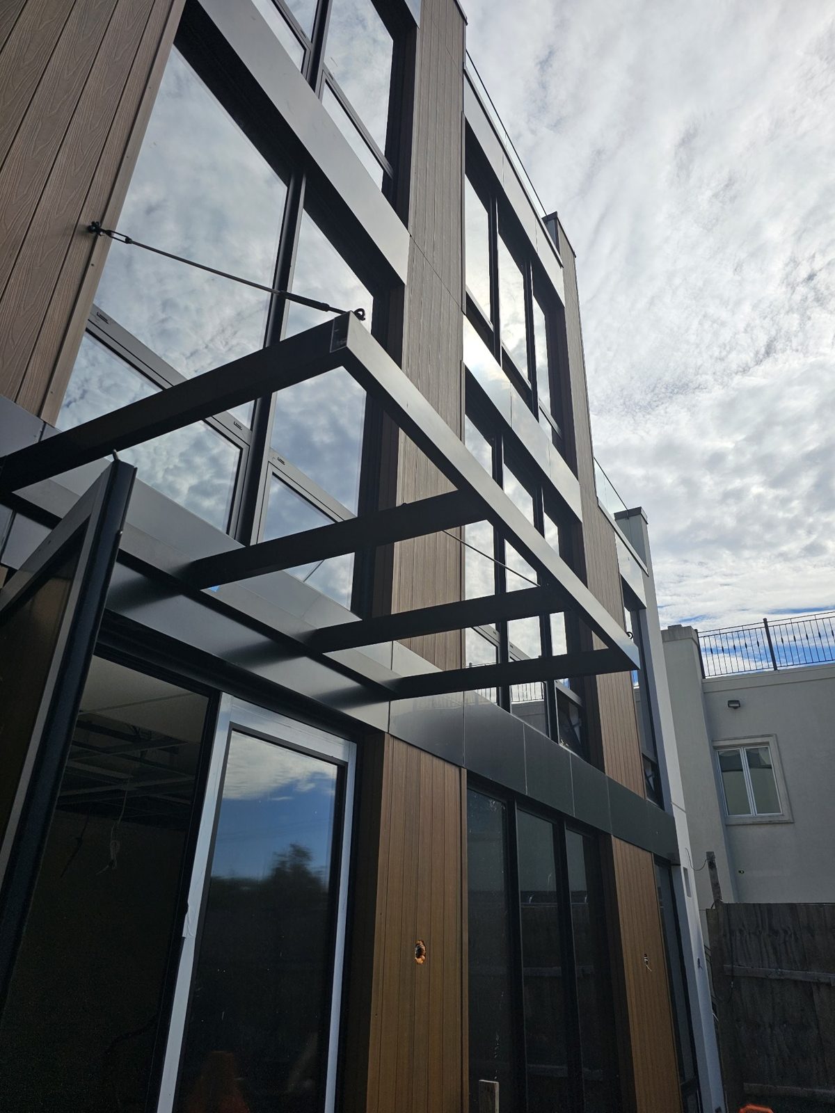 Side view of the cantilevered canopy and the ACM spandrel band at 75-65 186th Street, Queens