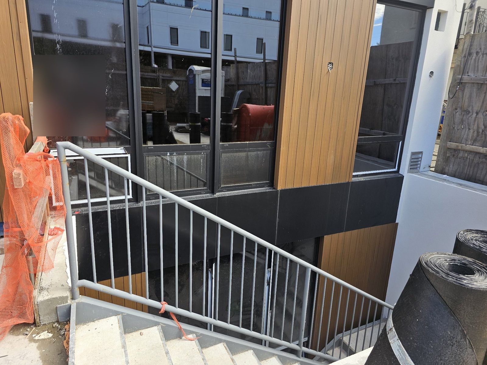 Ground-floor ACM base and window wall beside the exterior stair at 75-65 186th Street, Queens