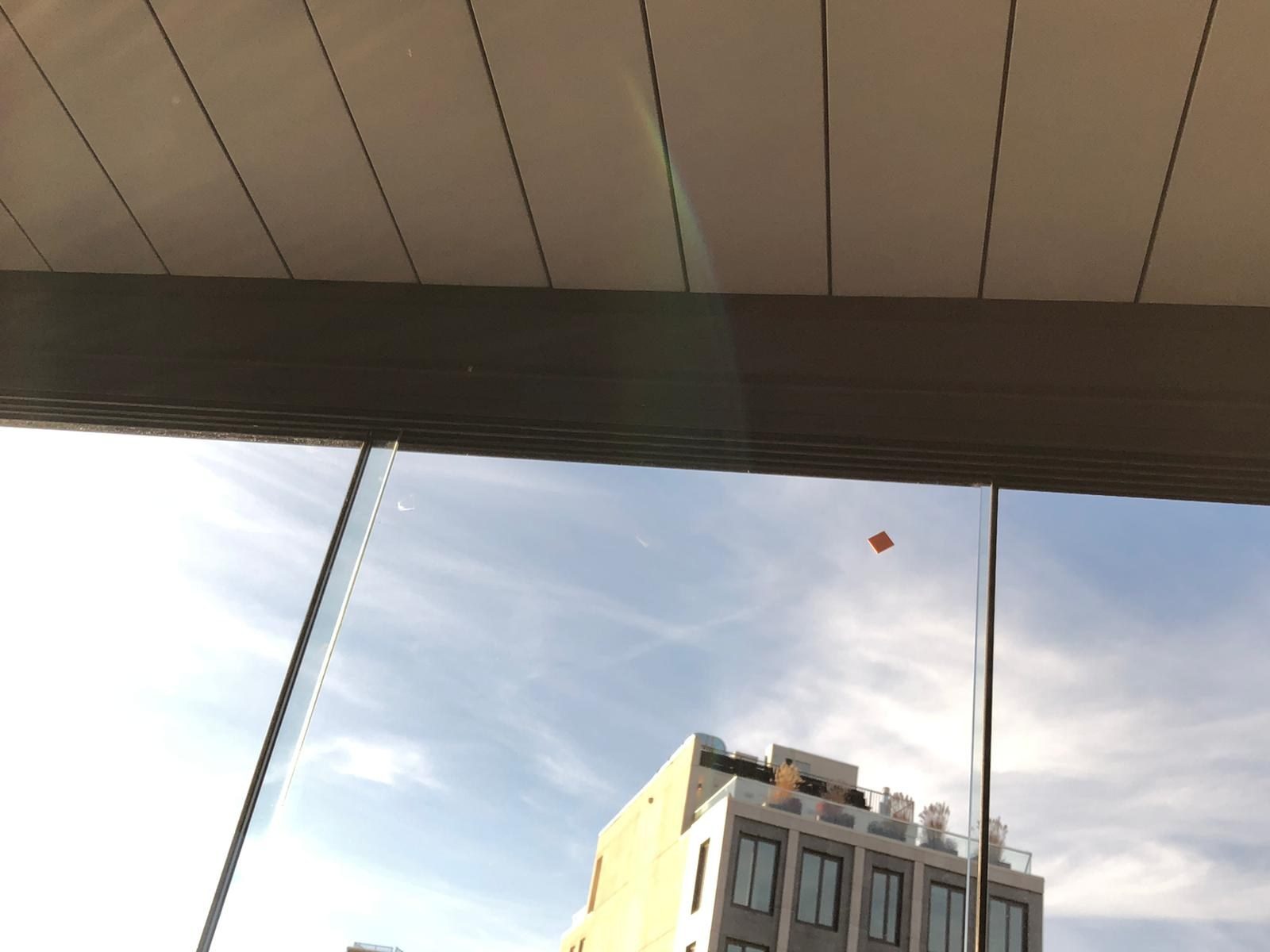 Closed aluminum roof louvers seen from inside the pergola sunroom at 86 Washington Avenue, Brooklyn, above the sliding glass panels