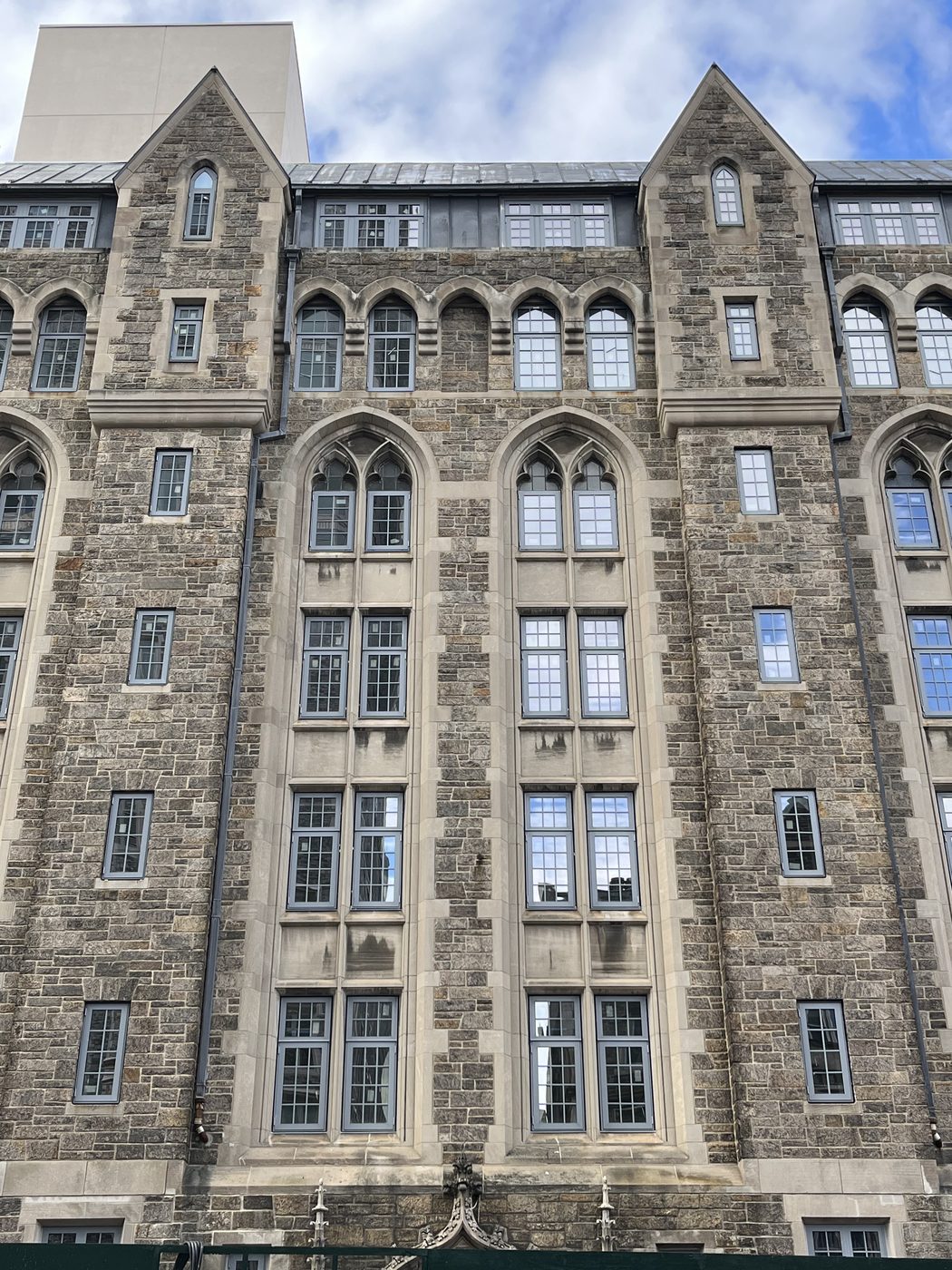 Tall two-light Gothic bays with stone tracery heads and new divided-lite aluminum windows, 99 Claremont Avenue, Manhattan