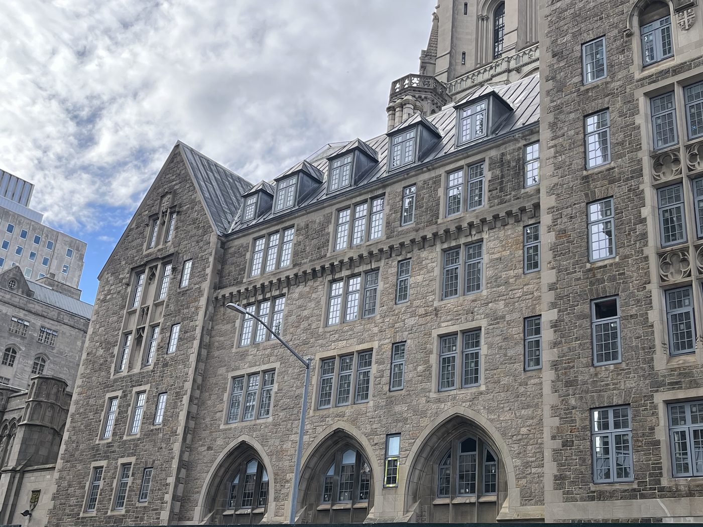 Roof dormers, corbelled string course and pointed-arch ground-floor windows with new aluminum units, 99 Claremont Avenue, Manhattan