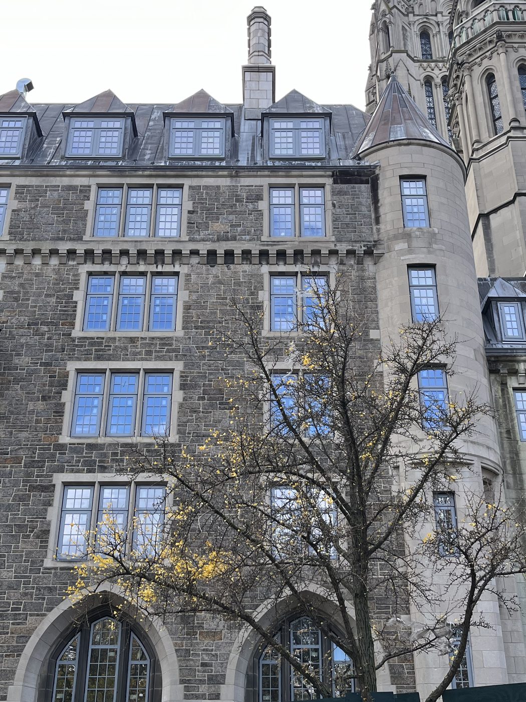 Corner turret with conical roof and small aluminum windows beside paired divided-lite units, 99 Claremont Avenue, Manhattan