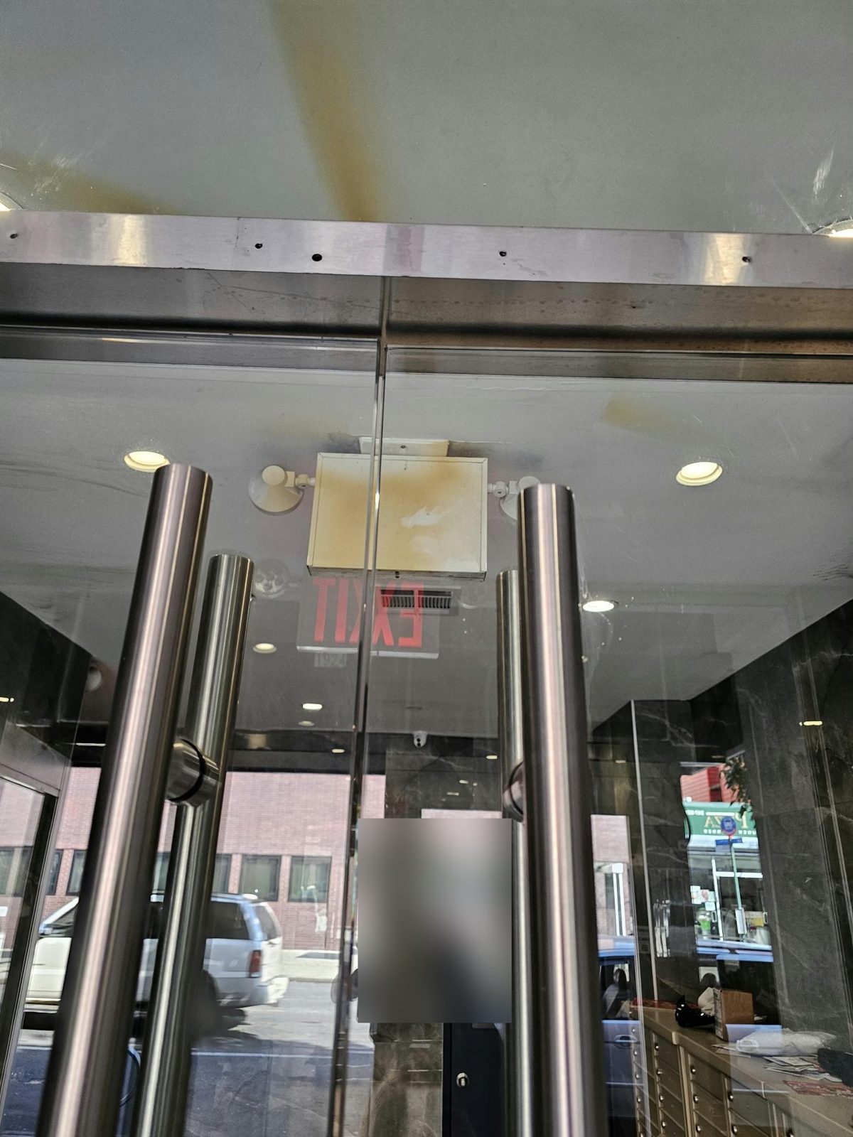 Full-height tubular pulls and stainless header with closers on herculite lobby doors at Avenue M and Ocean Avenue, Brooklyn
