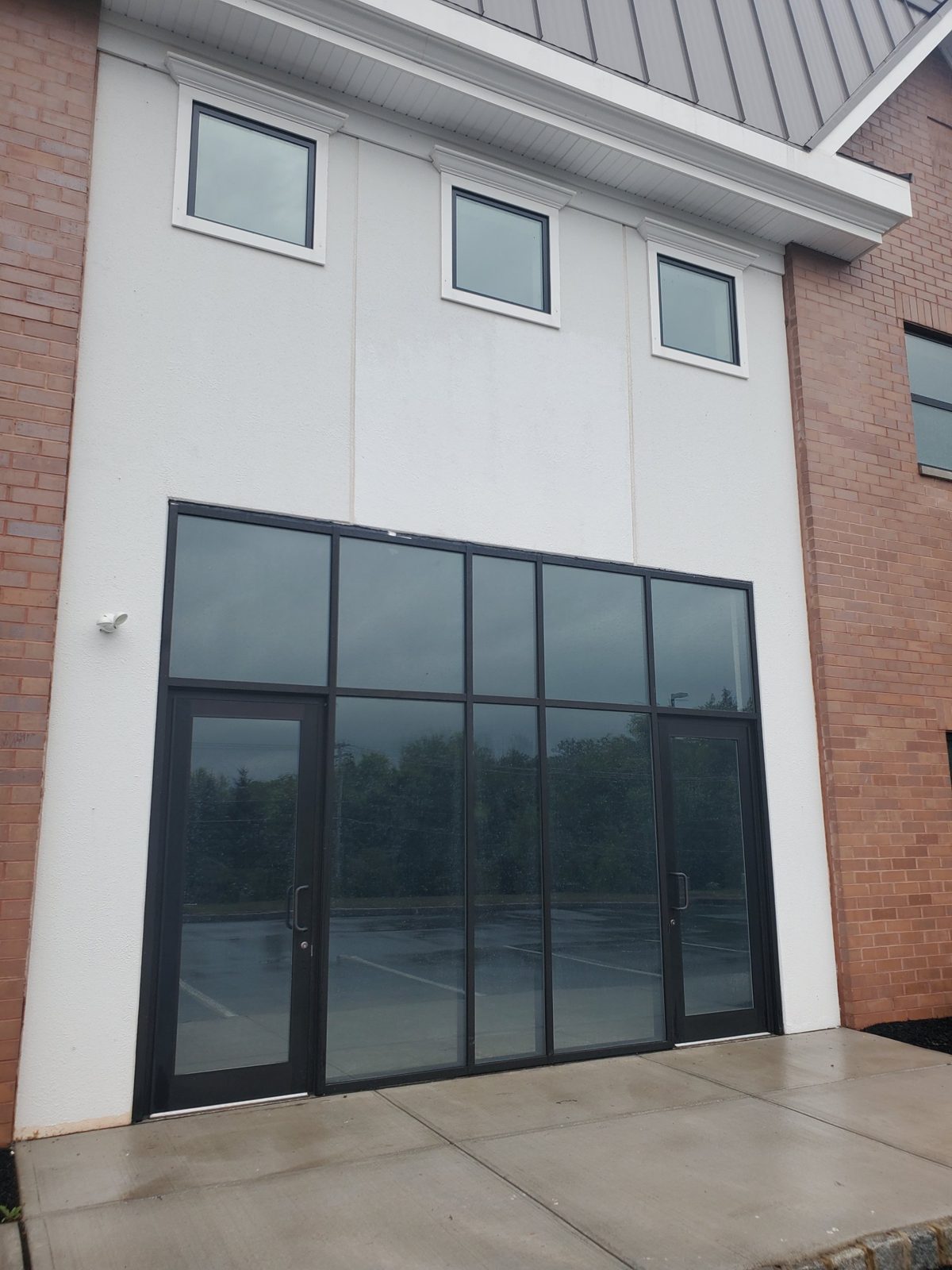 YKK storefront with two glass doors, transom lights and highly reflective glass at the entrance of a warehouse in Central New Jersey