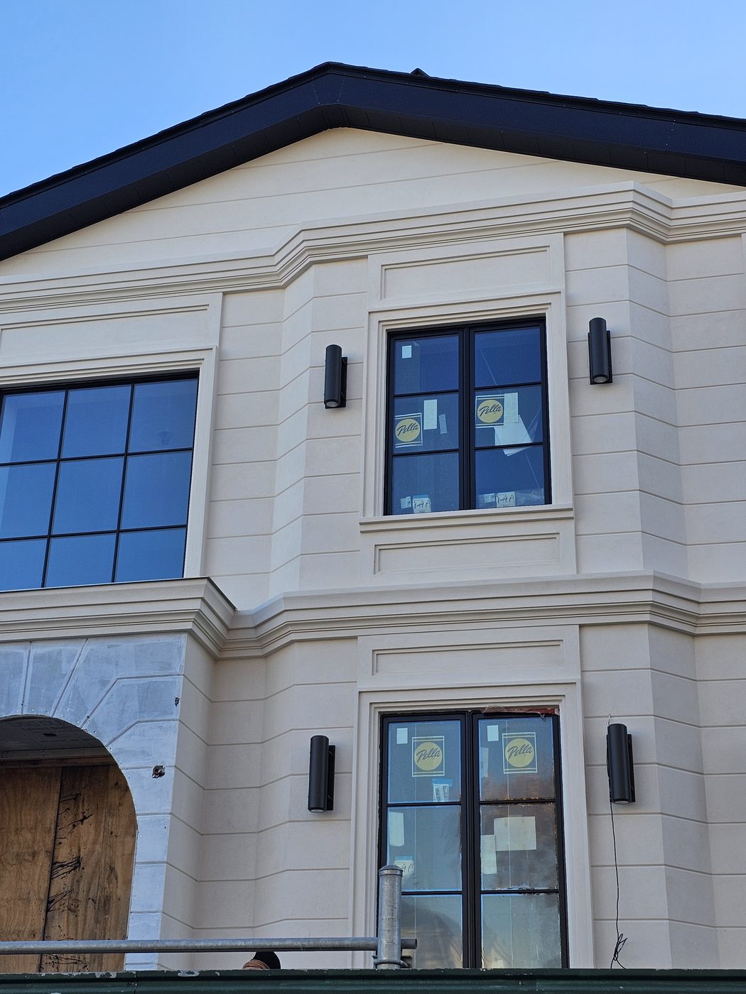New house on Coleridge Street, Manhattan Beach, with black Pella casement windows and a French door in a pale stucco facade