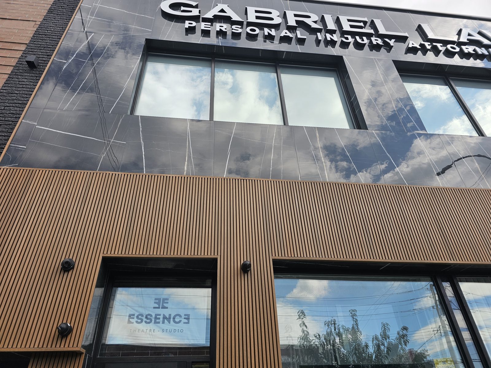Upper facade with black granite tile, aluminum-framed windows and spandrel glass, Brooklyn storefront replacement