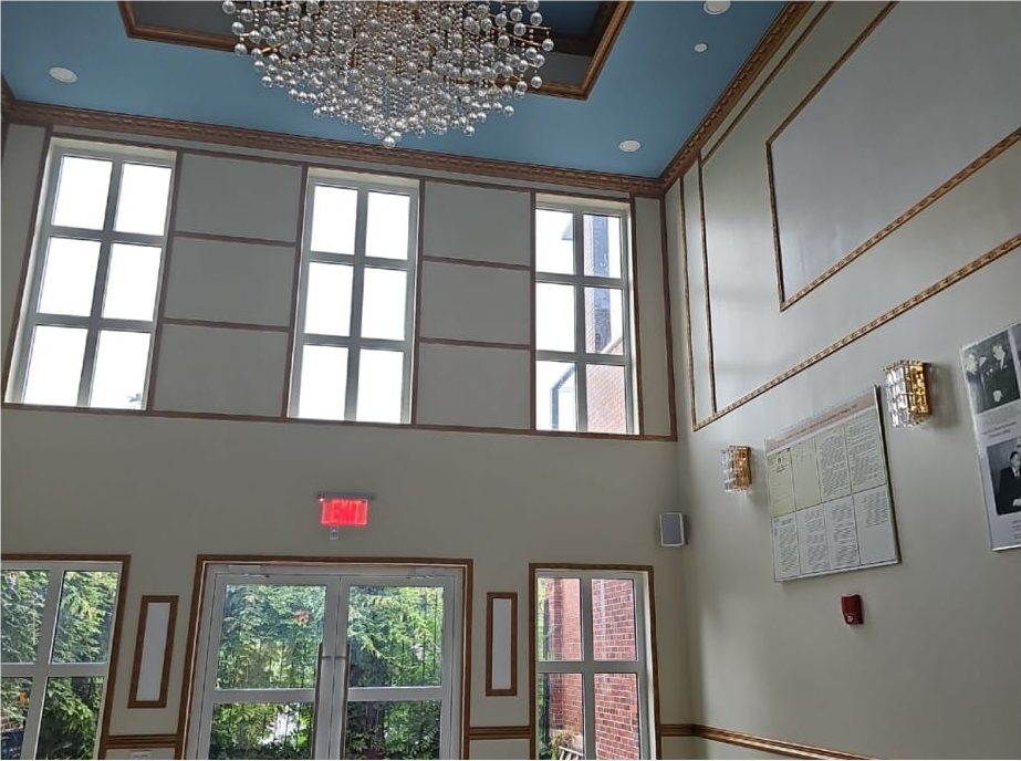 Finished double-height reception hall at the Embassy of Tunisia, New York, with multi-pane Alutech windows on two levels, blue ceiling and chandelier