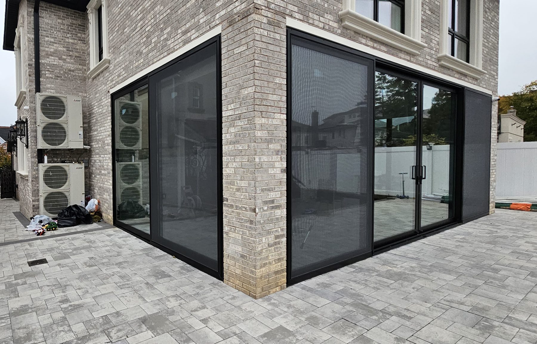 The sunroom wrapping the corner - glazing on two elevations with a single continuous frame line &mdash; Jamaica Estates, Queens