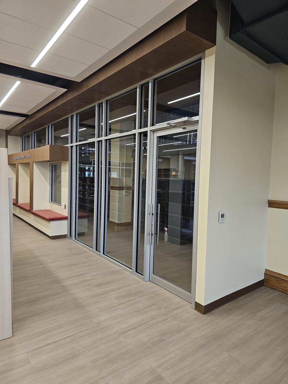 Full-height glass partition wall with transom lites and a glass door enclosing the Puerto Rican Community Archives at the Newark Public Library, Newark NJ