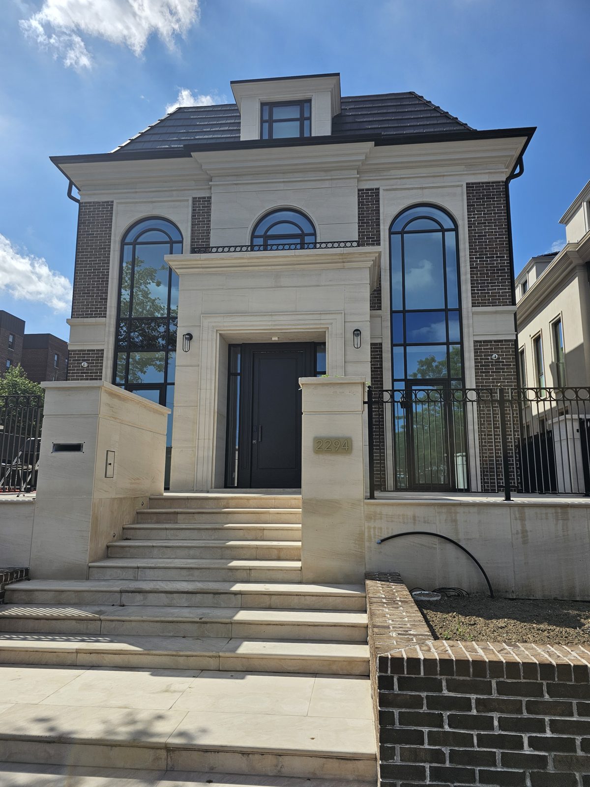 Front elevation of a new limestone custom house at Ocean Parkway and Avenue W, Brooklyn, with Reynaers arched windows and a two-storey glazed entry slot