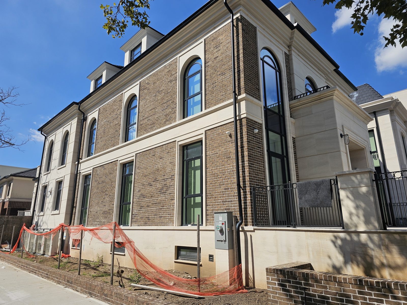 Full side elevation of the house showing arched windows, quoins and dormer