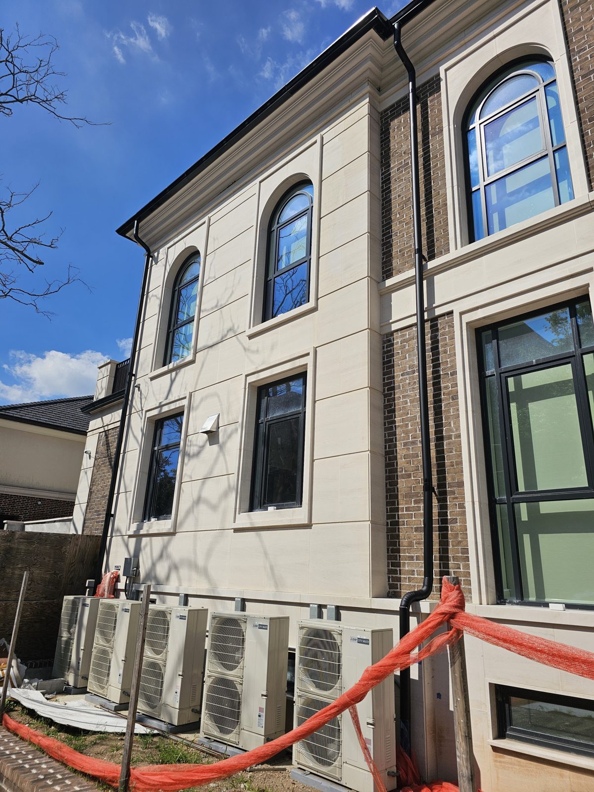 Corner of the house with arched and rectangular slim-profile aluminum windows