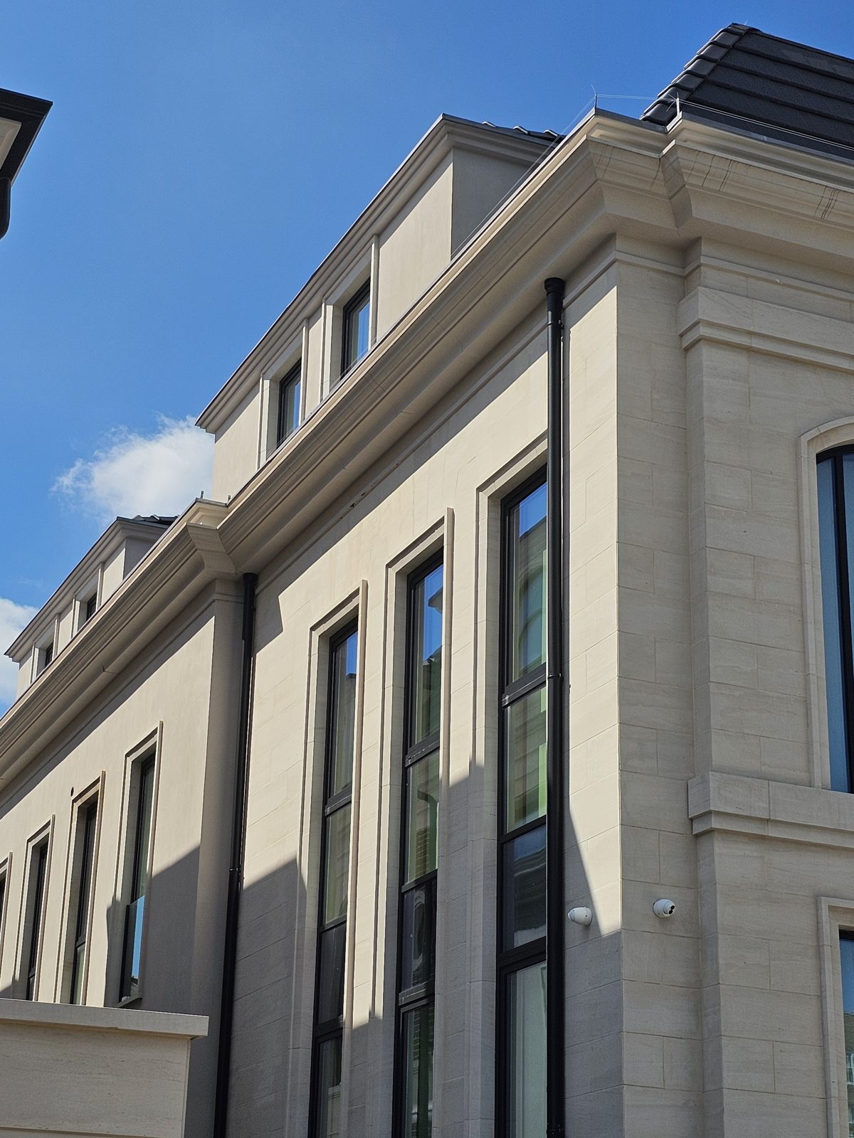 Limestone side elevation with slim vertical windows and an arched window