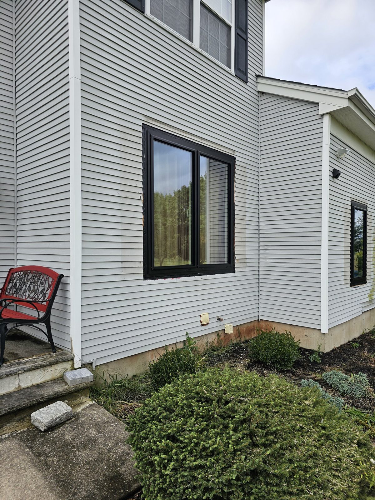Paired black aluminium window on the side elevation of a colonial house in Somerset NJ, white vinyl siding