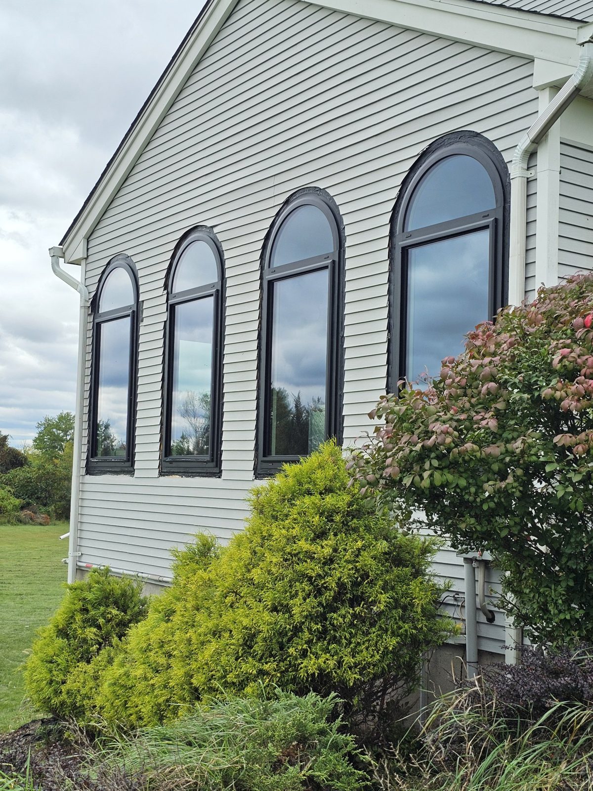 Four tall arched black aluminium windows on the gable end of a colonial house in Somerset NJ