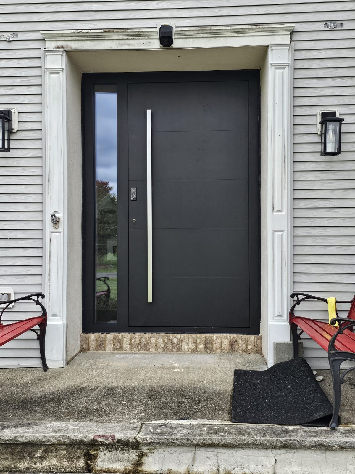 Flush black aluminium entrance door with full-height sidelite, long stainless bar pull and fingerprint reader, inside a white pilaster surround, Somerset NJ