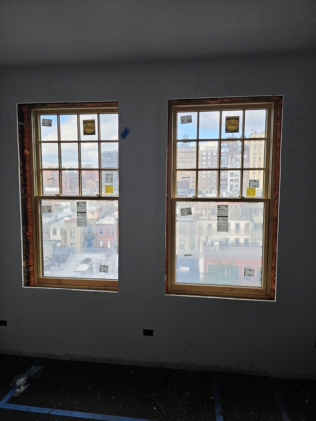 Paired double-hung units with matching divided upper sashes, foamed and ready for trim &mdash; Upper West Side, Manhattan