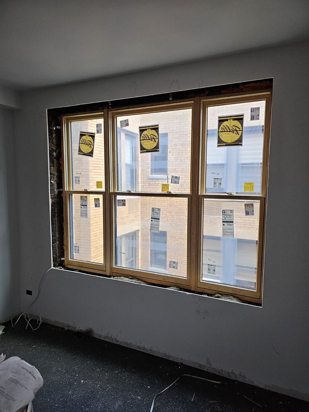 A three-wide unit set into the opening, with the original masonry jamb exposed alongside &mdash; Upper West Side, Manhattan