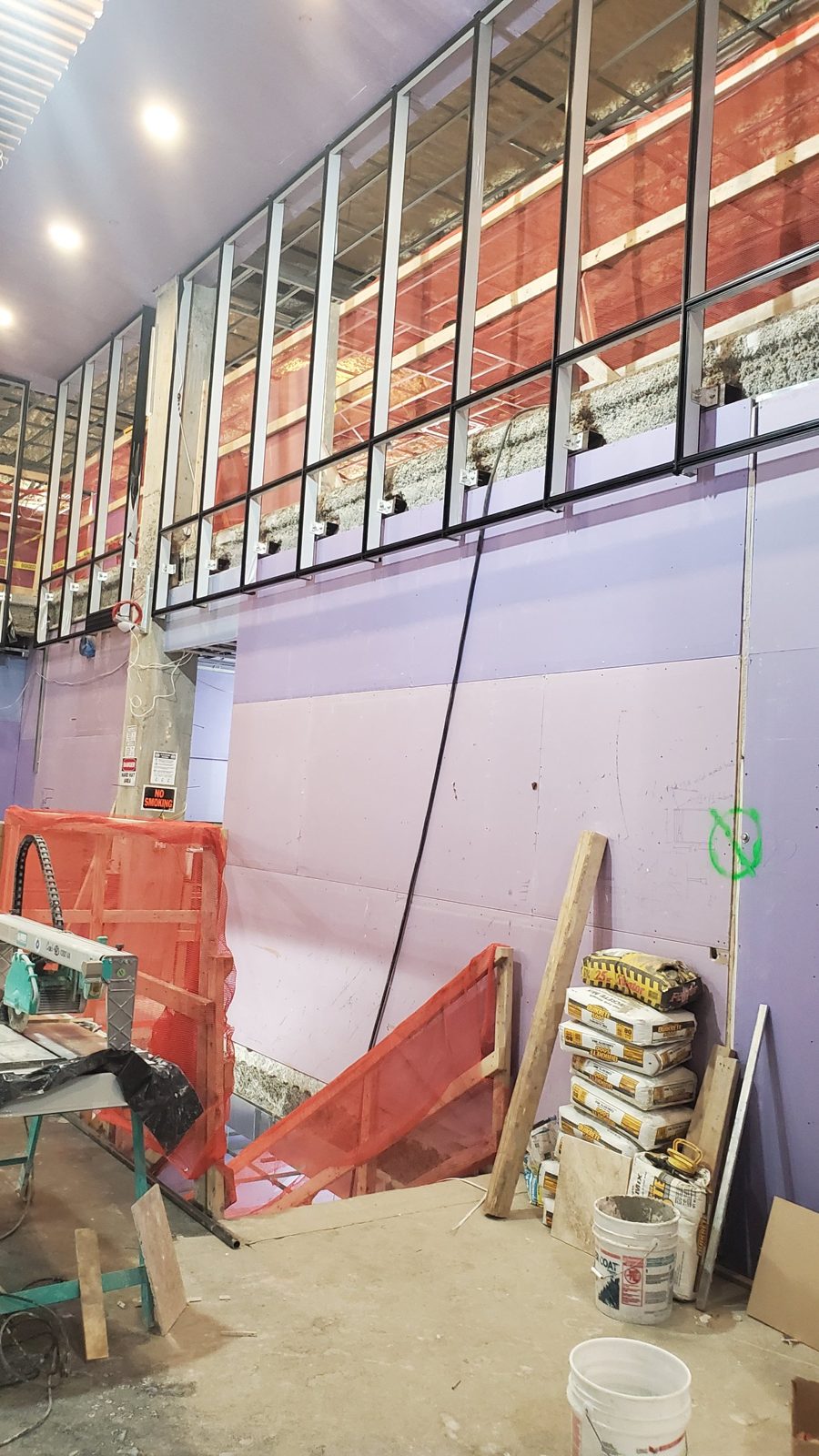 Curtain wall framing with anchor clips at the slab edge during installation at World Spa, Brooklyn